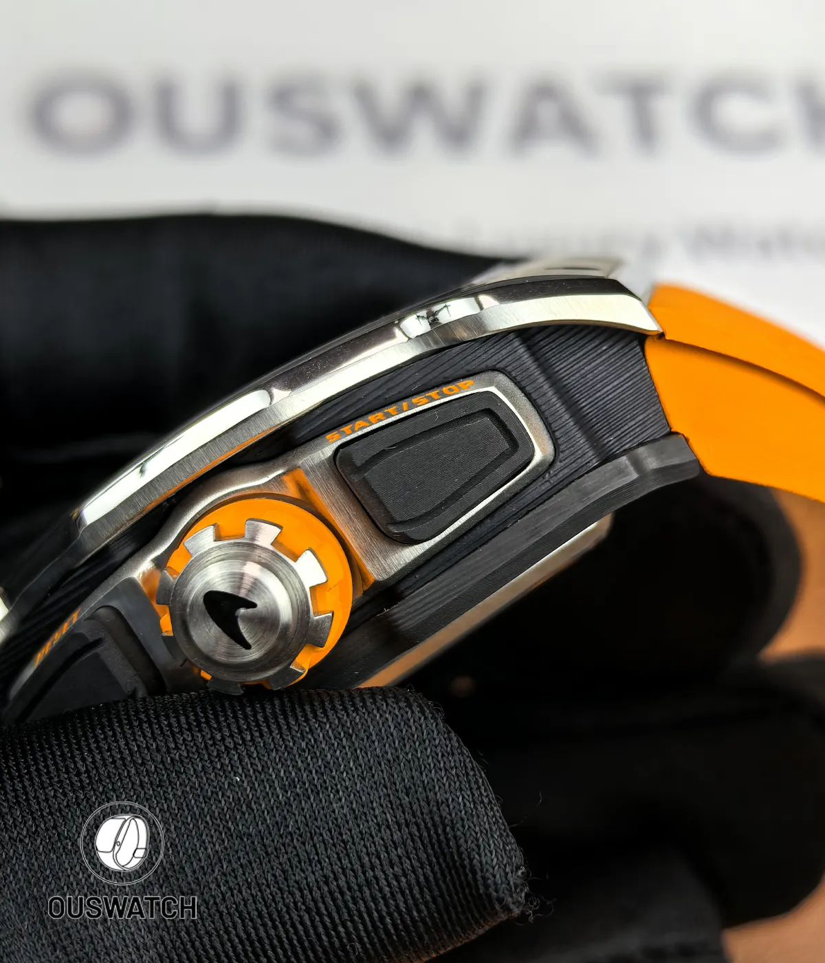 Contrast composition of titanium frame and carbon composite case, emphasizing mixed-material construction and finish.