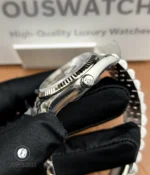 Detailed view of the signed winding crown and crown guards with visible machining lines.