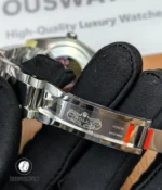 Engraved Rolex coronet logo on the inside of the 126200 folding clasp captured in sharp macro detail.