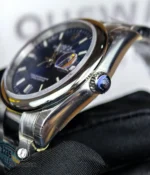 Macro of the smooth bezel and signed crown on the 36mm Datejust 126200 highlighting finishing details.