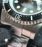 Tight shot of the black ceramic bezel insert with its engraved diving scale and crisp numeral relief.