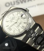 Close-up of the fluted bezel on Rolex Land-Dweller 127334-0001 showing edge detail and finish.