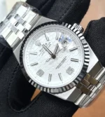 Macro close-up of the white dial on Rolex Land-Dweller 127234 showing hour markers and hands.