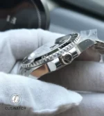 Macro of the case flank and screw-down crown on the 116610LN, showing machining texture and crown guards.