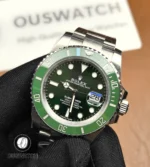 45° angled view highlighting the Submariner’s crown guard, bezel edge and the sunburst green dial.