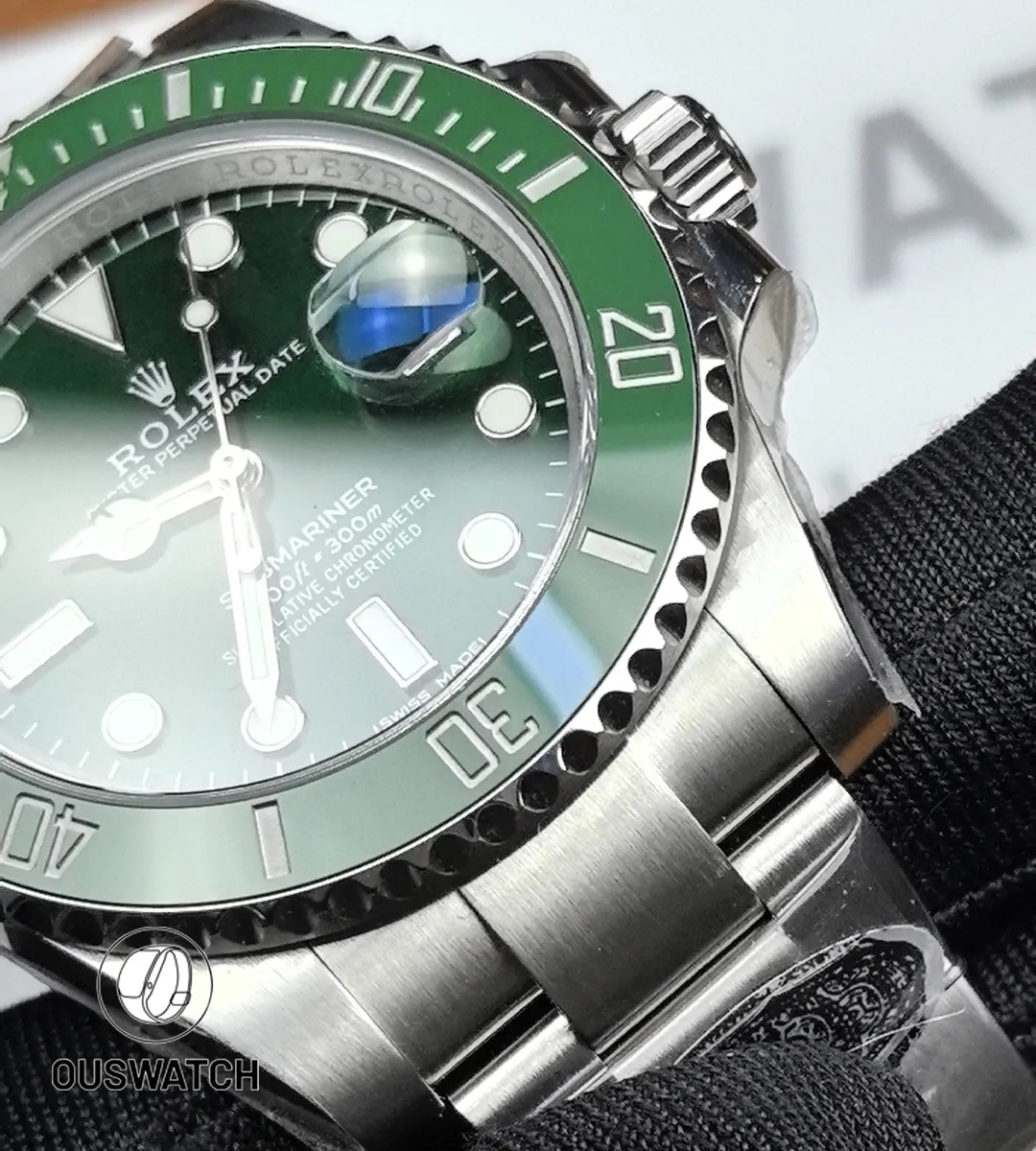Tight shot of the green ceramic bezel meeting the brushed stainless-steel case, showing bezel teeth detail.