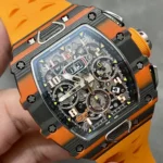 RM 11-03 McLaren orange edition — composition focusing on the carbon case contrast and vivid orange dial accents.