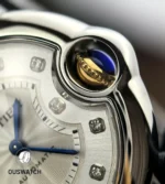 Close-up of the Ballon Bleu crown highlighting the fluting and gem/cabochon detail beside the diamond dial.