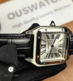 Watch lugs and attached black leather strap showing stitching and fit.