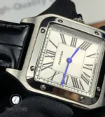 Dial close-up featuring blue sword-shaped hands and Roman numeral hour markers.