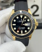 Front view of the Rolex Yacht-Master 42 super clone ref. 226658 with black dial, yellow-gold tone case, and Oysterflex-style strap.