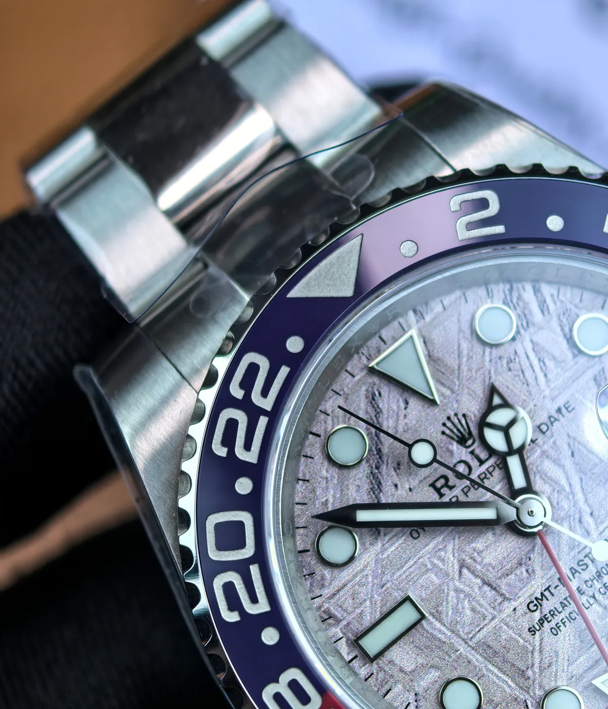 Close-up of the Rolex Pepsi meteorite dial texture with GMT hand and luminous hour markers.